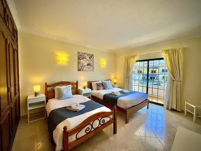 a hotel room with two beds and a balcony at Albufeira Summer Villa 1 With Pool by Homing in Albufeira