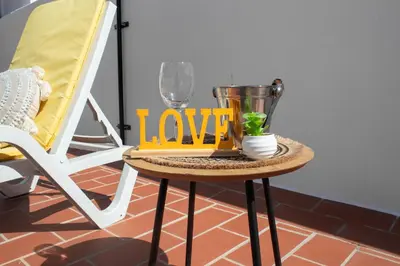 a table with a love sign on it next to a chair at Casa Amarela - Conforto e localização central! in Faro