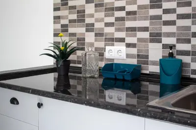a kitchen counter with a sink and a vase with a plant at Casa Amarela - Conforto e localização central! in Faro