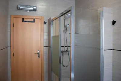 a shower with a glass door in a bathroom at Casa Amarela - Conforto e localização central! in Faro