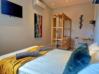 a bedroom with a bed with a tv on the wall at Campus 121 - Rooms in Faro