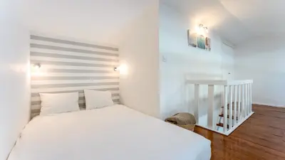 a bedroom with a white bed with a striped headboard at Relaxing Beach House in Alfamar by LovelyStay in Albufeira