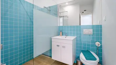 a blue tiled bathroom with a toilet and a sink at Relaxing Beach House in Alfamar by LovelyStay in Albufeira