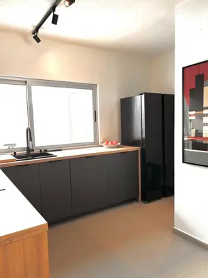 a kitchen with a black refrigerator and two windows at Casa Vale do Lobo in Vale do Lobo