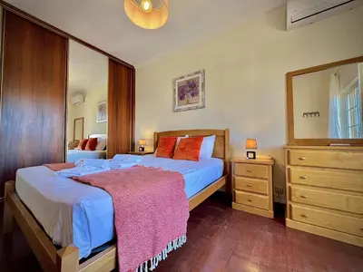 a bedroom with a bed and a dresser and a mirror at Albufeira Summer Villa 2 with Pool by Homing in Albufeira