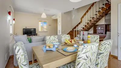 a dining room with a table and a couch at T3 Triplex Vista Mar Marina de Vilamoura-Greice Homes in Vilamoura
