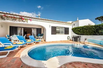 a pool with chaise lounge chairs and a swimming pool at Mng Elliott55 in Vale do Lobo