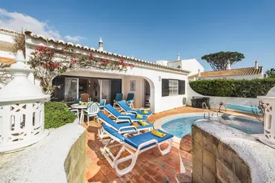 a patio with blue chairs and a swimming pool at Mng Elliott55 in Vale do Lobo