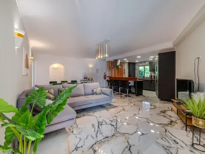 a living room with a couch and a kitchen at Apartment T2 Cassias VIP Properties by Interhome in Vilamoura