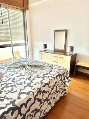 a bedroom with a bed and a dresser with a mirror at Apartamento Faro - T3 in Faro