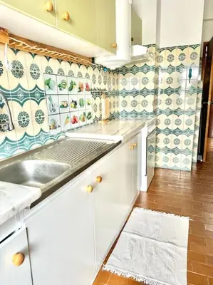 a kitchen with white cabinets and a sink at Apartamento Faro - T3 in Faro