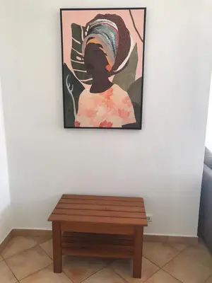 a painting of a girl on a wall next to a table at Casa Golfinho, Albufeira in Albufeira