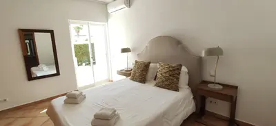 a bedroom with a white bed and a mirror at Casa Golfinho, Albufeira in Albufeira