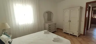 a bedroom with a bed and a dresser and a mirror at Casa Golfinho, Albufeira in Albufeira