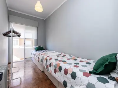 a bedroom with a bed with a comforter on it at Akisol Faro Sunny in Faro