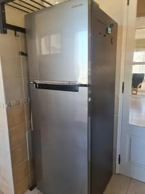 a stainless steel refrigerator in a kitchen next to a door at FERIAS NA PRAIA in Albufeira