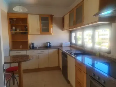 a kitchen with wooden cabinets and a counter top at FERIAS NA PRAIA in Albufeira