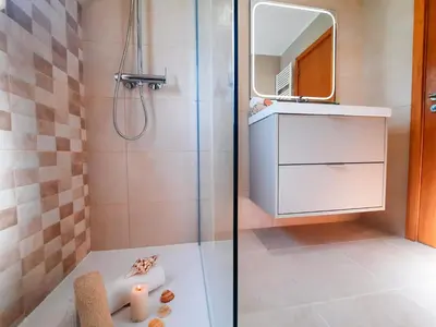 a bathroom with a shower with a sink and a mirror at Villa Dolce Vita by Algarve Vacation in Albufeira