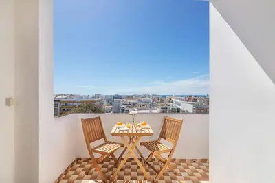 a table and chairs on a balcony with a view at Quarteira Mar à Vista T1 in Quarteira