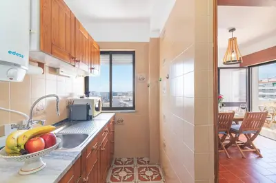 a kitchen with a sink and a bowl of fruit at Quarteira Mar à Vista T1 in Quarteira