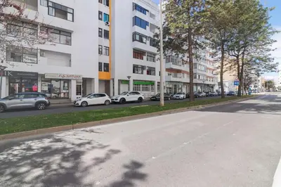 a street with cars parked in front of a building at Quarteira Mar à Vista T1 in Quarteira
