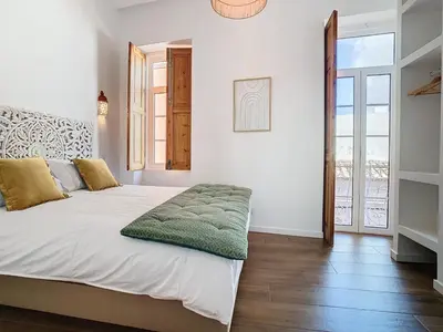 a bedroom with a bed with a green blanket on it at CASA NOAVA in Loulé