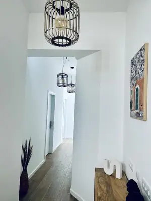 a hallway with white walls and two chandeliers at CASA NOAVA in Loulé