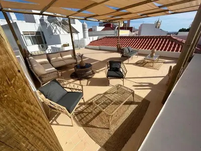 an outdoor patio with chairs and a grill at CASA NOAVA in Loulé