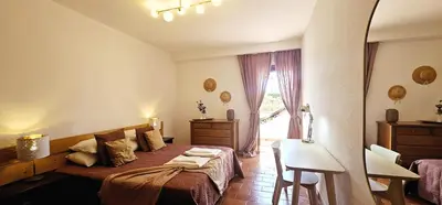a bedroom with a bed and a table and a window at Beach House Vidinha in Albufeira