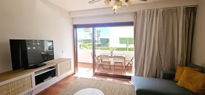 a living room with a couch and a television at Beach House Vidinha in Albufeira