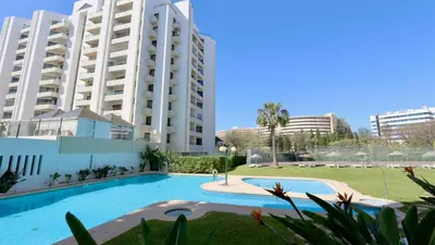 a swimming pool in front of two large buildings at Al Charb TopFloor sea view, ar con, pool - CleverDetails in Vilamoura