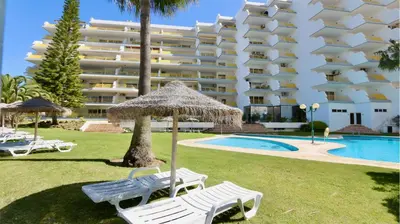 a resort with two chairs and an umbrella and a pool at Al Charb TopFloor sea view, ar con, pool - CleverDetails in Vilamoura