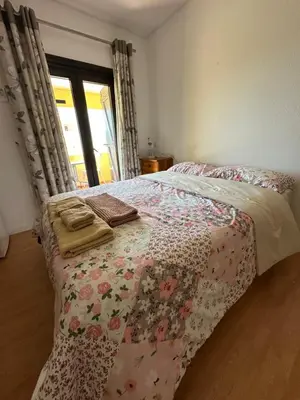 a bedroom with a bed and a window with a door at Casa Amarela in Faro