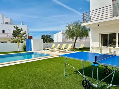 a ping pong table in the backyard of a house at Vila Nalia in Albufeira