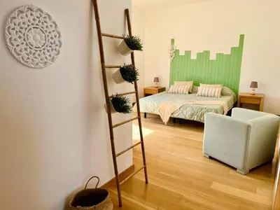a bedroom with a bed and a ladder and a chair at Vila Nalia in Albufeira