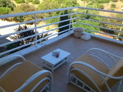 a balcony with chairs and a table and a white table at Lovely 2 Bedroom S Jose Apartment in Albufeira