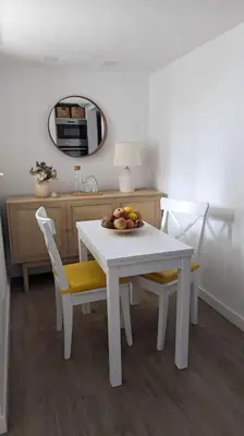 a white table and chairs with a bowl of fruit on it at Casa da Aldeia in Olhos de Água