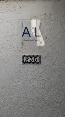 a sign on the side of a white wall at Casa da Aldeia in Olhos de Água