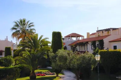 a group of palm trees and buildings in a park at Old Village, 2 bedrooms, 5 ppl, Beach, Golf, Padel in Vilamoura