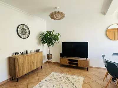 a living room with a flat screen tv and a table at Casa Esperança in Albufeira