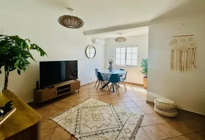 a living room with a tv and a table at Casa Esperança in Albufeira