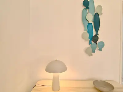 a lamp sitting on a table next to a wall withstract at Fig Villa- CleverDetails, Sleep 8, Pool, Children Playground, Ténis court in Vilamoura