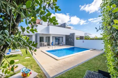 a villa with a swimming pool in a yard at Villas Novochoro - Small Garden by DreamvillasAlbufeira in Albufeira