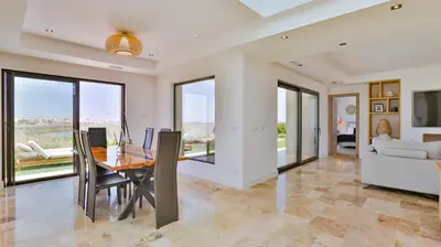 a dining room with a table and a couch at Brand New Waterfront Villa with pool in Faro