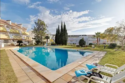 two beds in a room with two tables and two lamps at Marina Family Duplex with Pool in Quarteira