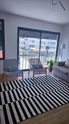 a living room with two chairs and a large window at Carmo City Center 2 in Faro