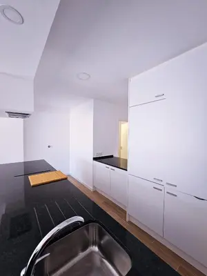 a kitchen with white cabinets and a stainless steel sink at Carmo City Center 2 in Faro