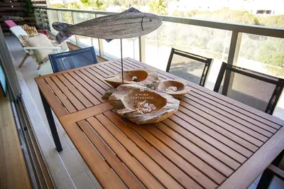 a wooden table with a bowl on top of a balcony at Apartment Terracota By Dalma Portuguesa in Albufeira