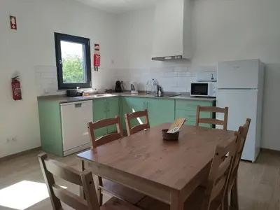 a kitchen with a wooden table and a table and chairs at Casa do Belé in Faro