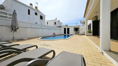a patio with chairs and a swimming pool in a house at Casa Catarina in Albufeira